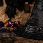 Chapeau de sorcière noir en velours sur table en bois sombre