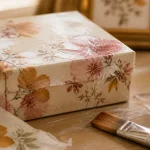 Loisirs créatifs serviettes en papier : serviettage sur boîte en carton, colle et plis visibles